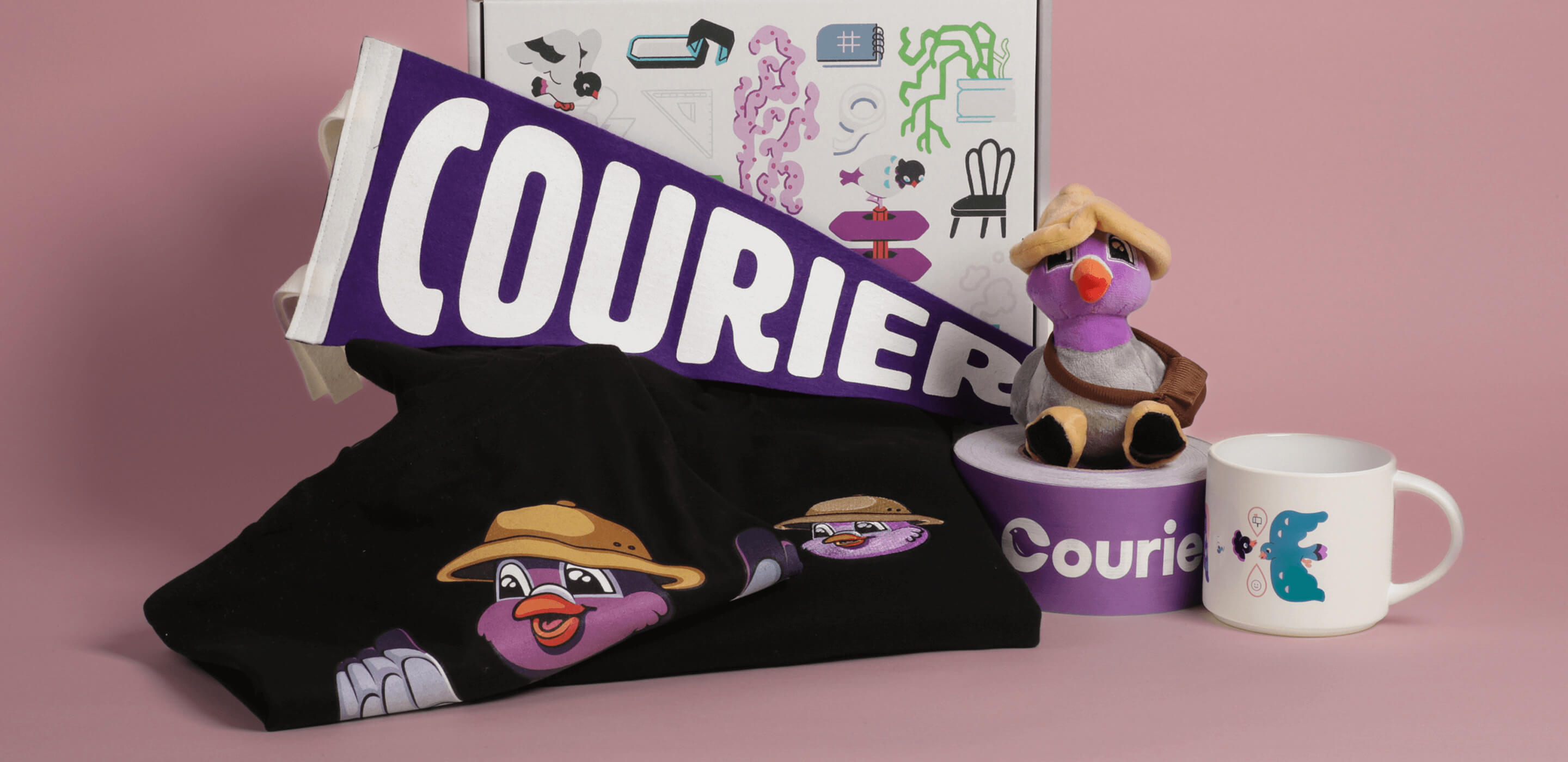 Photo of the welcome kit sent to Courier employees. The welcome kit box sits behind an assortment of swag, including a t-shirt with the company's mascot, Pip, and a plush of him, along with a mug, pennant, and packing tape with the Courier logo on it.