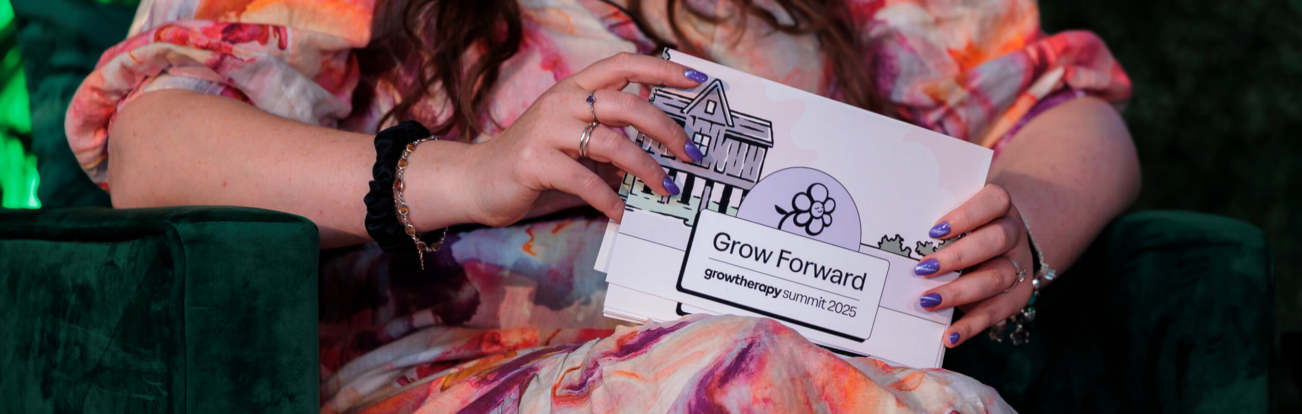Person holding speaker cards with the Grow Forward imagery and logo.